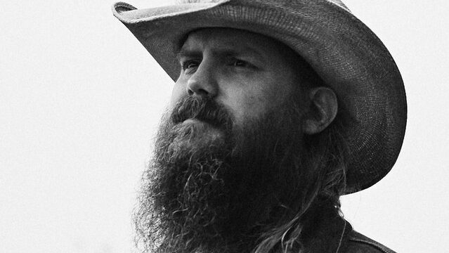 Chris Stapleton singing and playing guitar on stage during his All-American Road Show tour