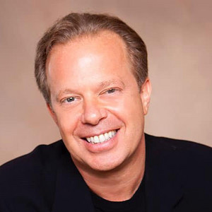 Joe Dispenza speaking on stage at a meditation workshop