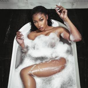 Megan Thee Stallion performing on stage in a sparkling outfit